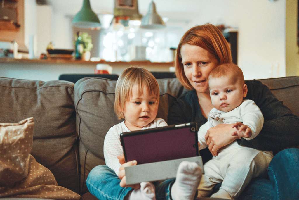 Mother with 2 children looking at a tablet