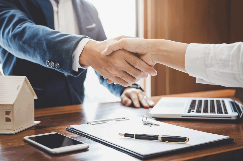 2 people shaking hands over the purchase of a new house